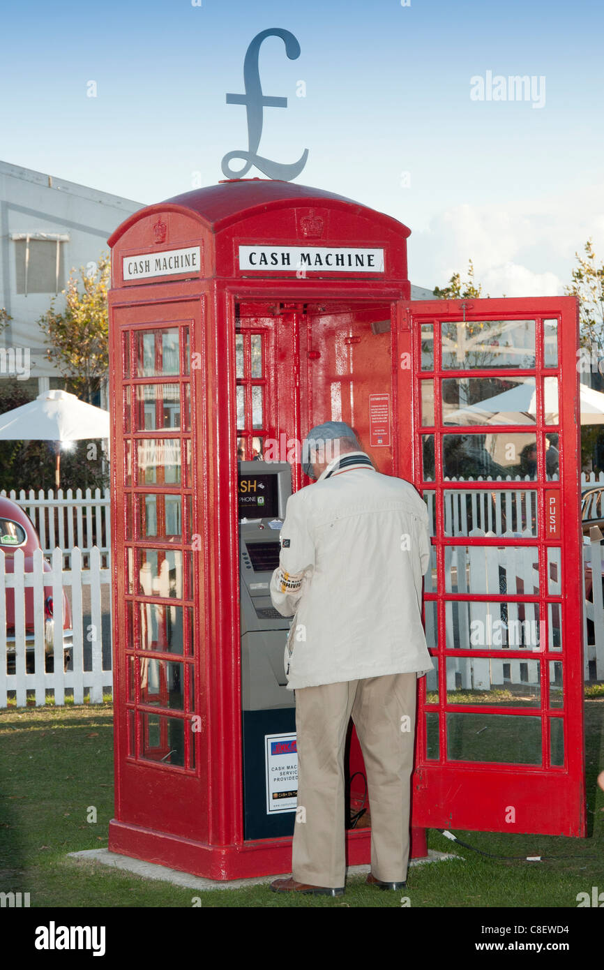 Mann mit einem Geldautomaten in eine alte rote Telefonzelle Stockfoto