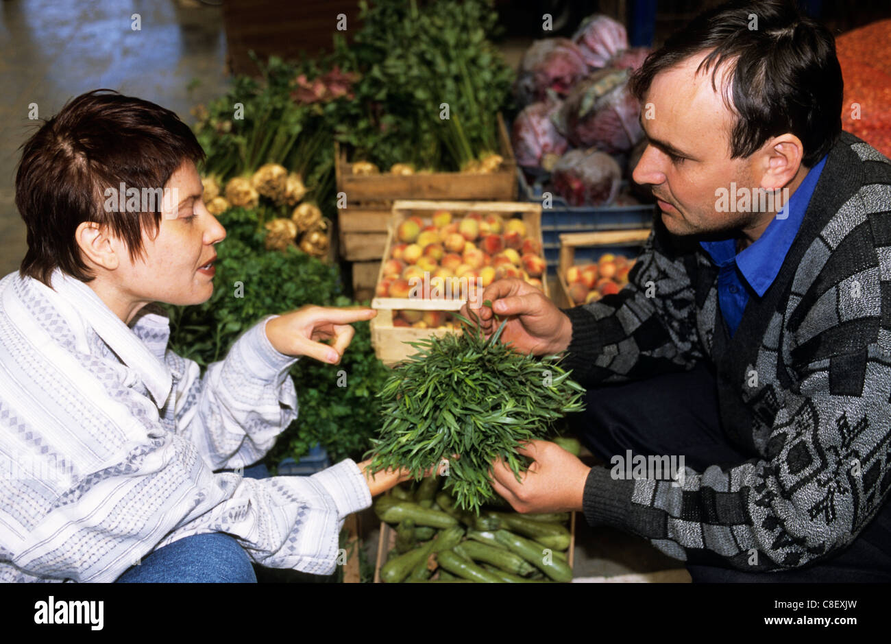 Bukarest, Rumänien. Diskussion über die Verwendung von Estragon mit einem Kunden Markt-Händler; viel frischem Gemüse. Stockfoto