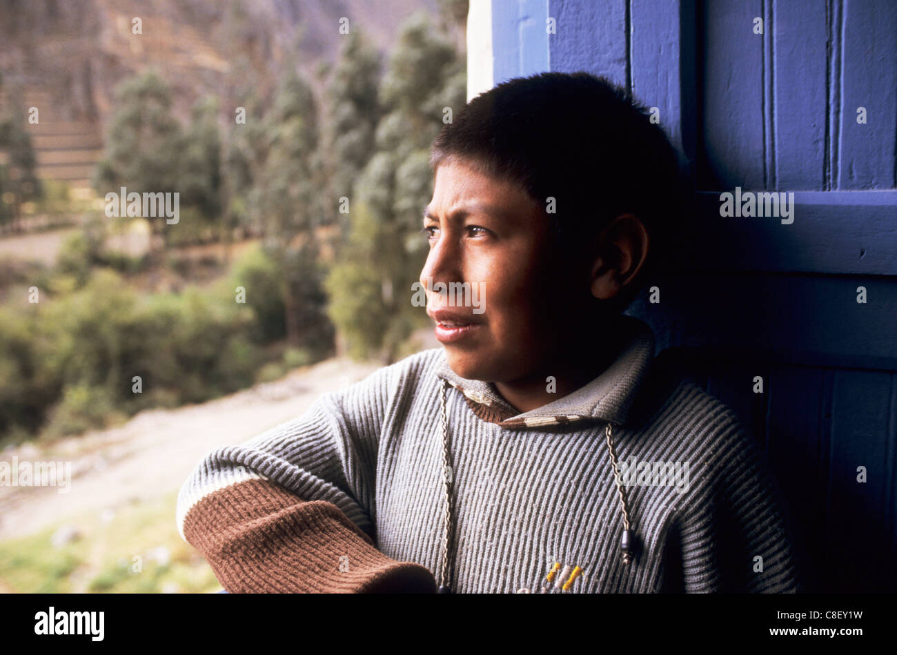 Ollantaytambo, Peru. Peruanischen Anden indischen Quechua junge Blick aus einem Fenster. Stockfoto