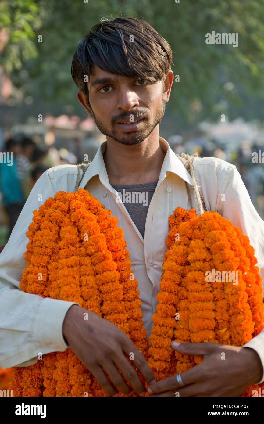 Junger Mann verkaufen Blumengirlanden in Delhi Morgen Blumenmarkt, Connaught Place, Neu Delhi, Indien Stockfoto