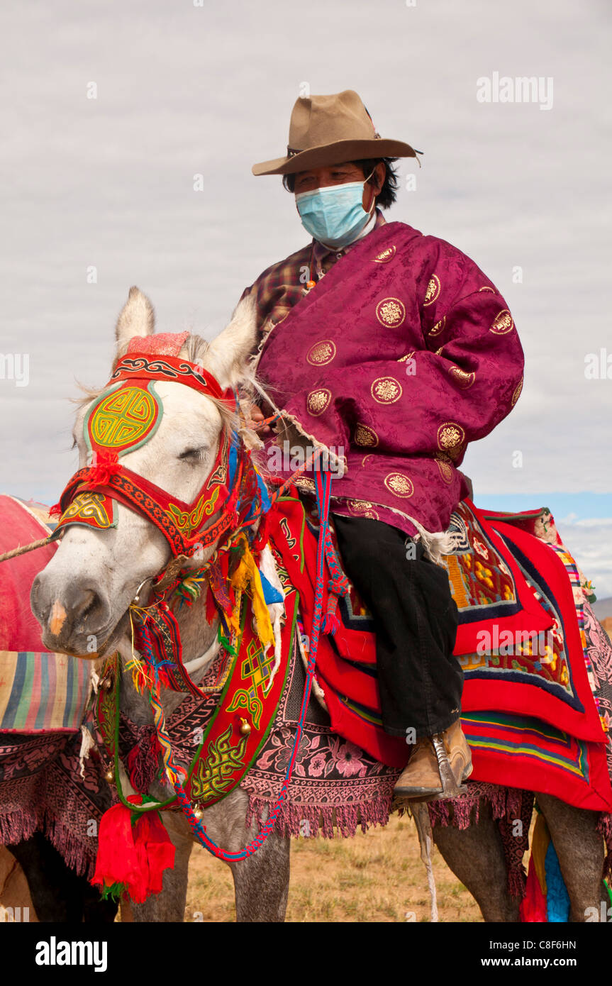 Reiter auf Colourfuly gekleidet Pferd in der Steppe von westlichen Tibet, China Stockfoto