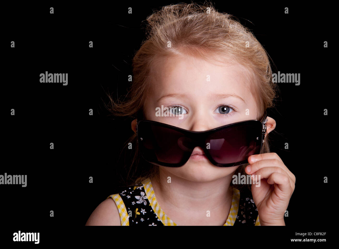 Eine Schauspielerin senkt ihre Sonnenbrille, auf den Betrachter zu suchen. Stockfoto