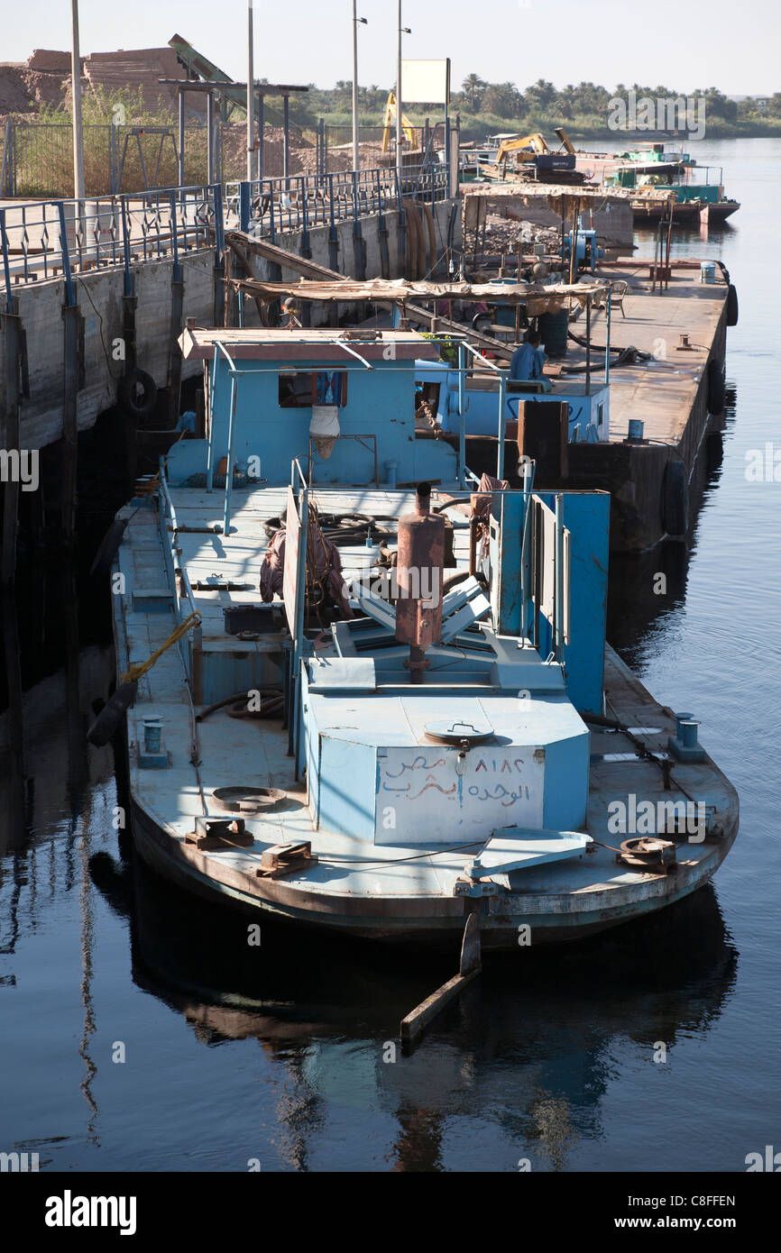 Leicht nach unten auf einem Schlepper arbeiten vertäut Heck gerichtete Kamera am Steg mit Reflexion in ruhigem Wasser, Fluss Nil Ägypten Stockfoto