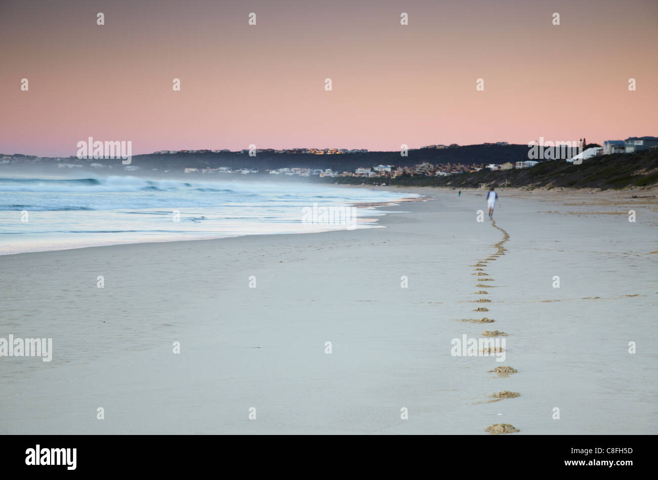 Mann, jogging am Strand bei Dämmerung, Plettenberg Bay, Western Cape, South Africa Stockfoto