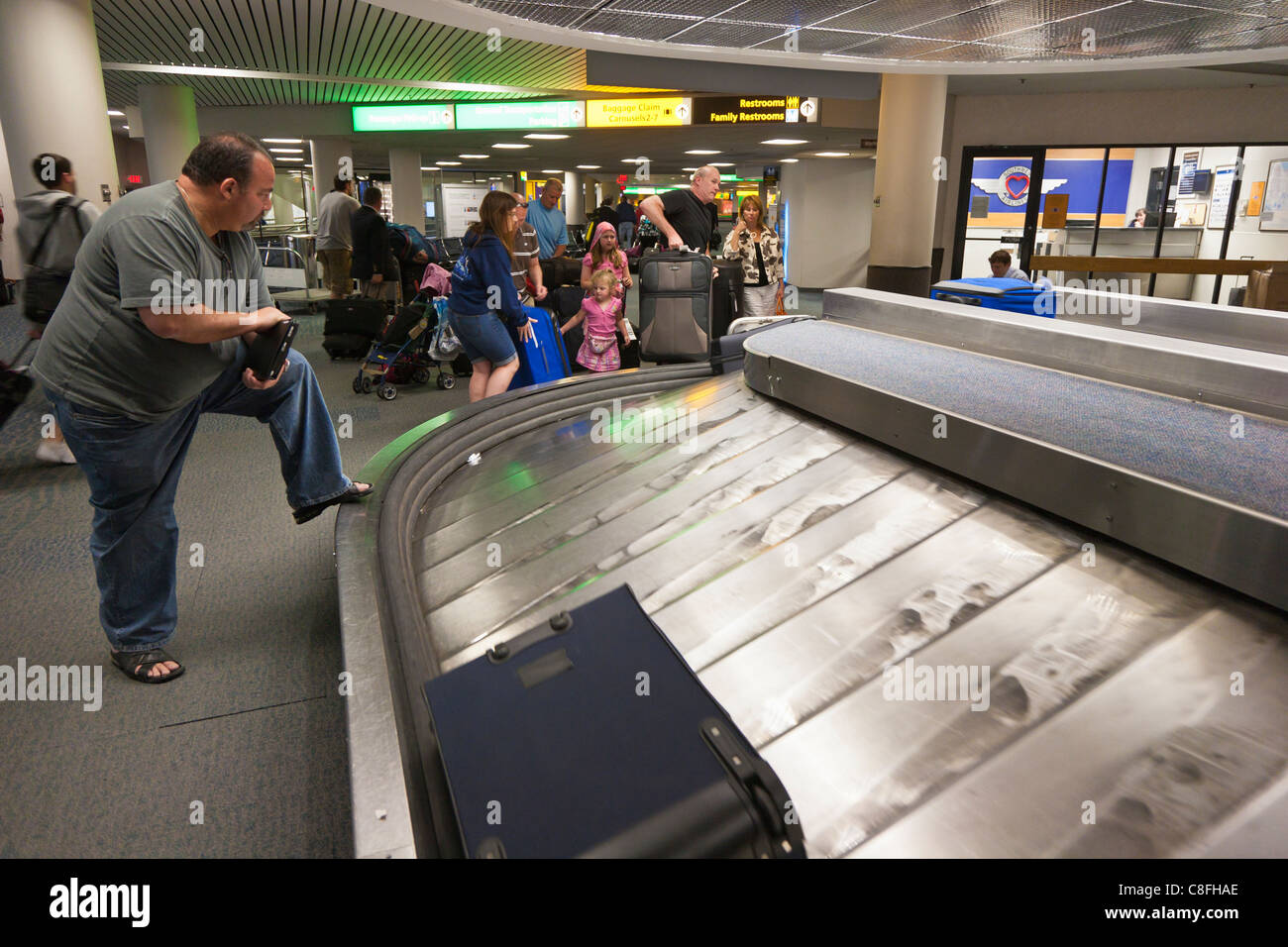 Übergewichtiger Mann warten auf Gepäck auf die Rückkehr von Gepäck am Flughafen in Columbus, Ohio Stockfoto