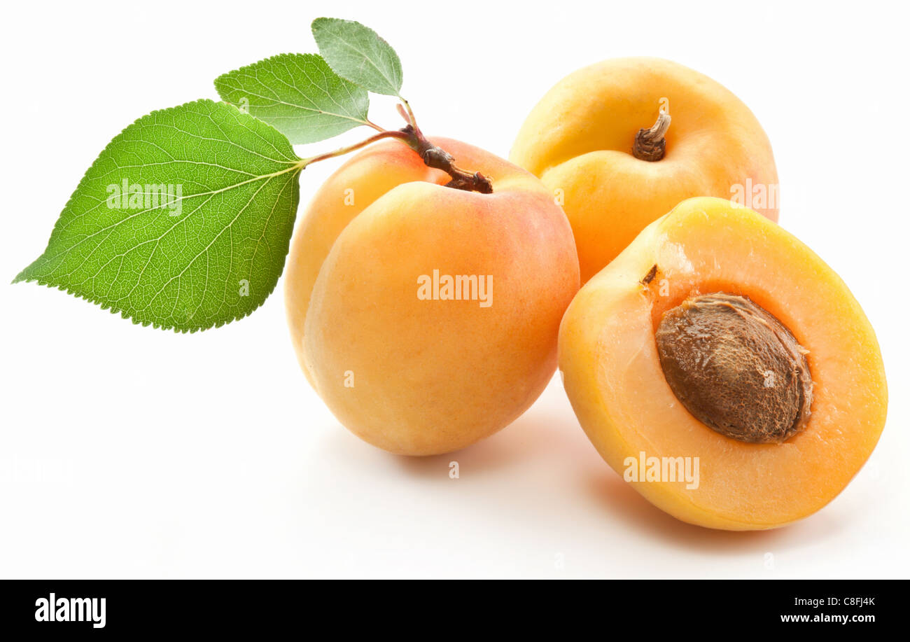 Aprikosen mit Blättern auf einem weißen Hintergrund. Stockfoto