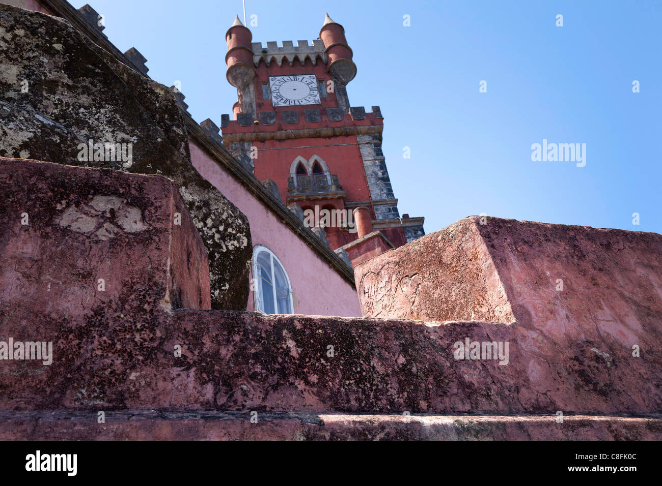 Grafitti-Herzen in rosa Steinmauern und Uhrturm Pena-Palast, Sintra gehauen Stockfoto