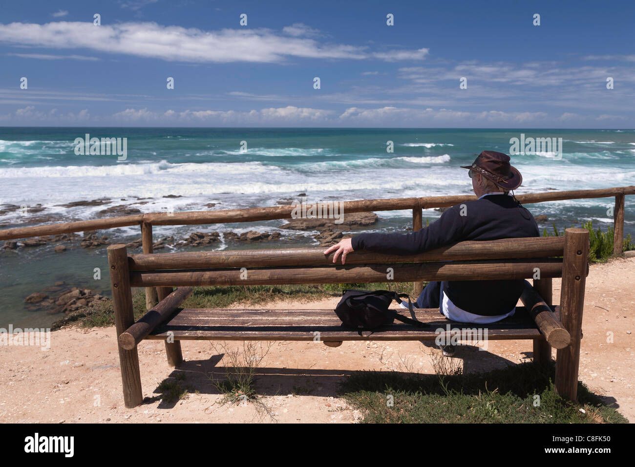 Westküste Portugals, in der Nähe von Lorinho, Mann sitzt auf einer Holzbank, die Wellen zu beobachten Stockfoto