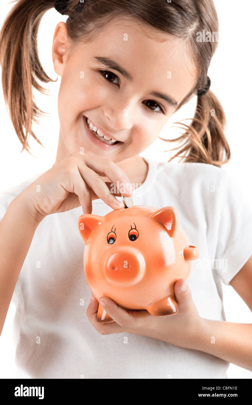 Kleines Mädchen hält ein Sparschwein und Einfügen von einem ein-Euro-Münze Stockfoto