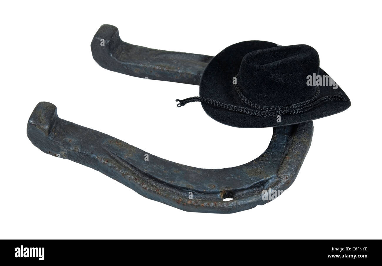 Schwarzer Cowboyhut auf eine alte abgenutzte Hufeisen, das in der Regel auf den Huf eines Pferdes - Pfad enthalten getragen wird Stockfoto