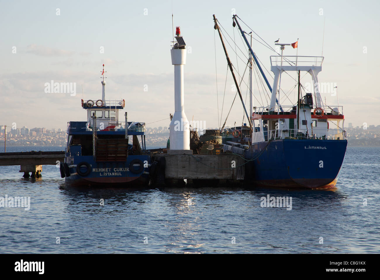 Großen Angelboote/Fischerboote angedockt am Pier auf der Insel Heybeliada mit asiatischen Seite von Istanbul im Hintergrund Stockfoto