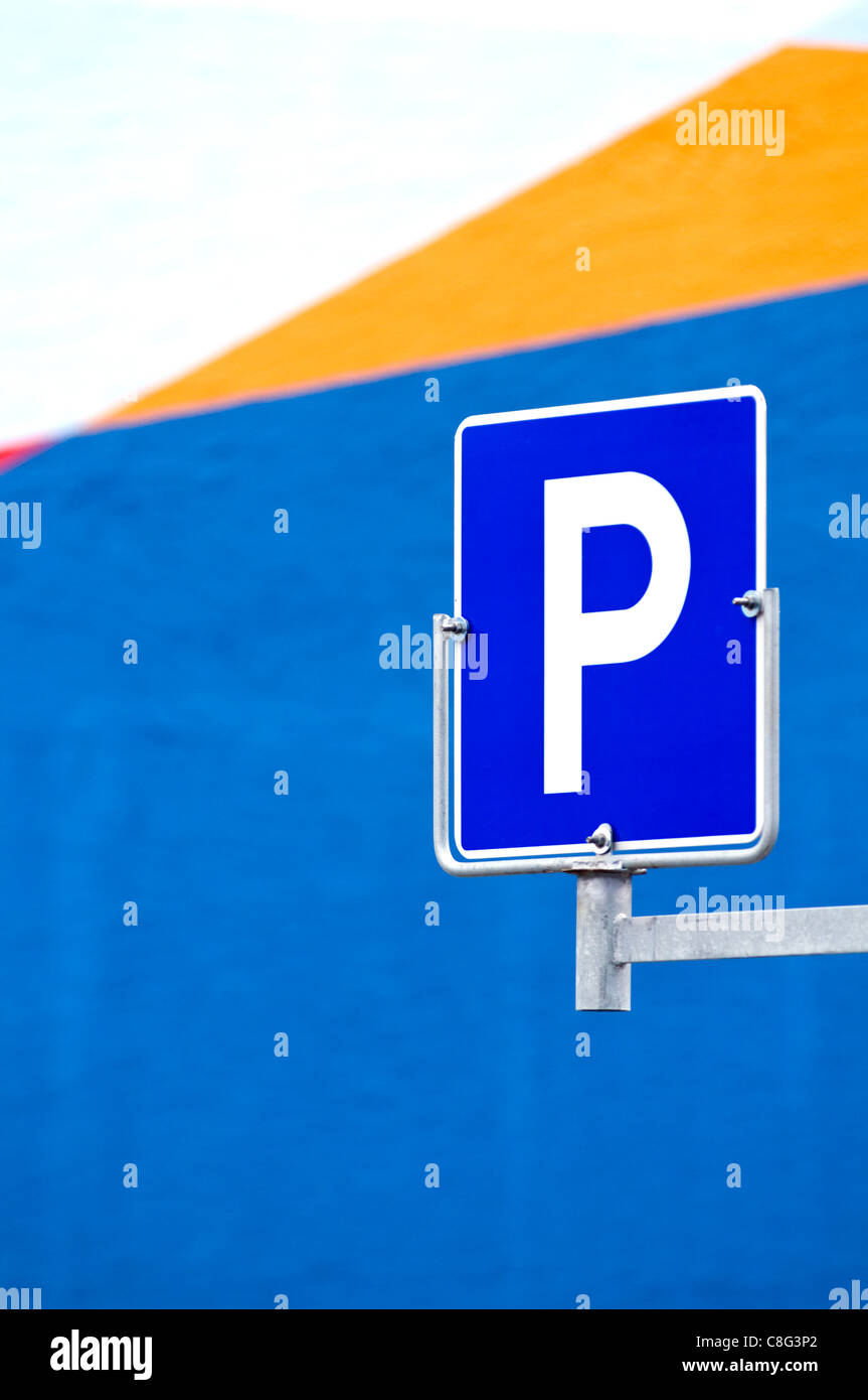 Ein Parkplatz-Zeichen vor einem bunten Gebäude Stockfoto