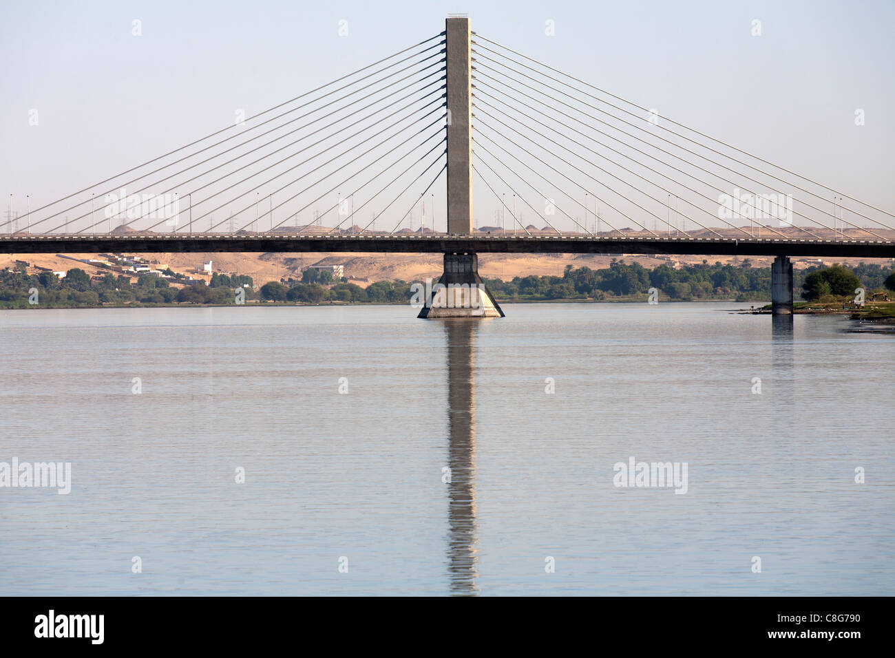 Nahaufnahme von Kabeln fanning aus einem Betonturm der Assuan-Hängebrücke spiegelt sich in den Fluss Nil, Ägypten Stockfoto