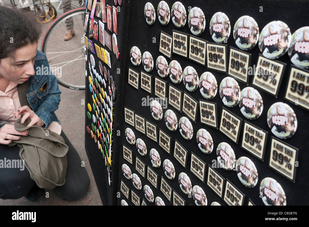 New York, NY - 23. Oktober 2011 Frau auf der Suche bei Occupy Wall Street, 99 % er und andere politische Tasten zum Verkauf in Liberty Square, Zuccotti Park. Stockfoto