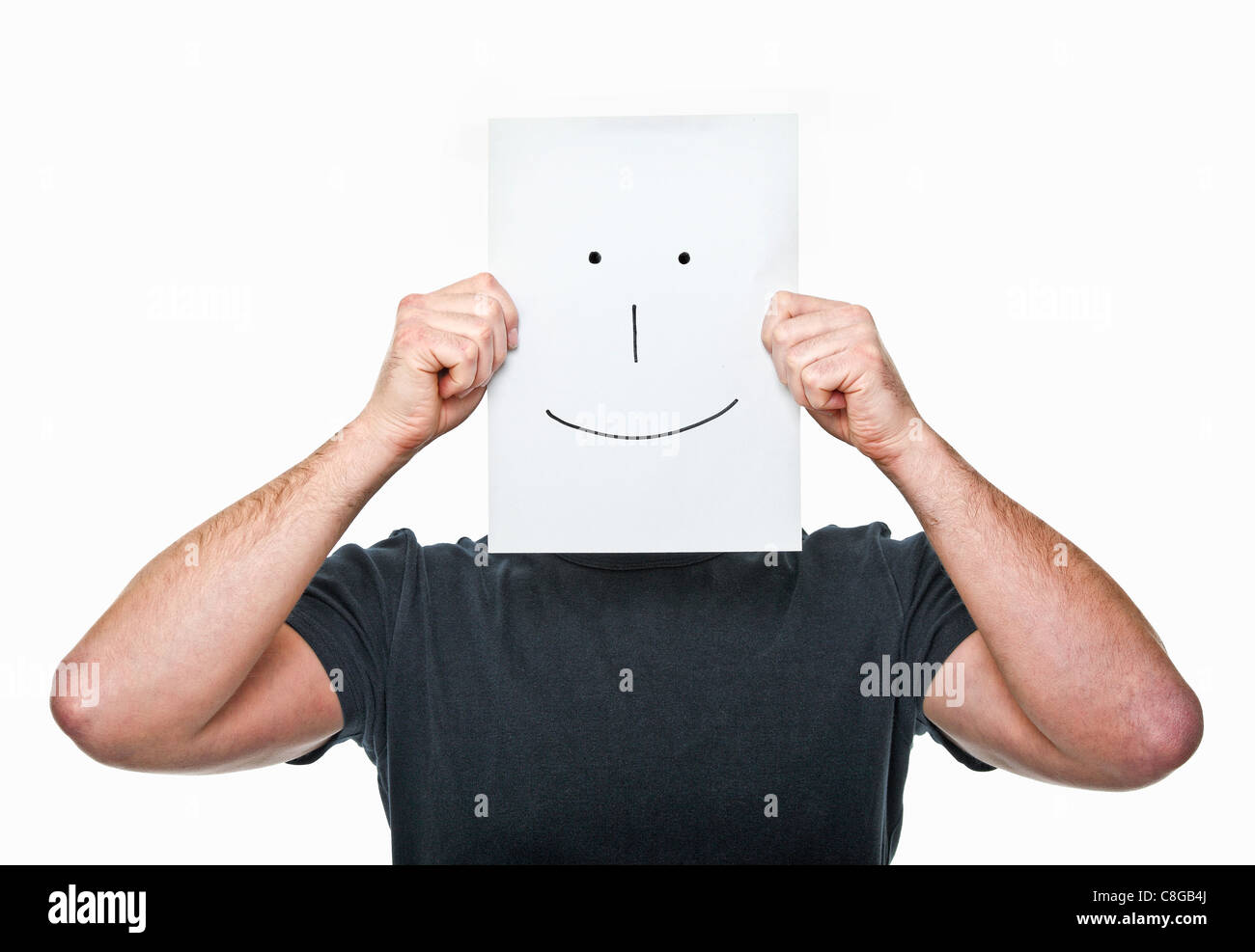 Mann versteckt sein Gesicht mit lächelnden Papier Stockfoto