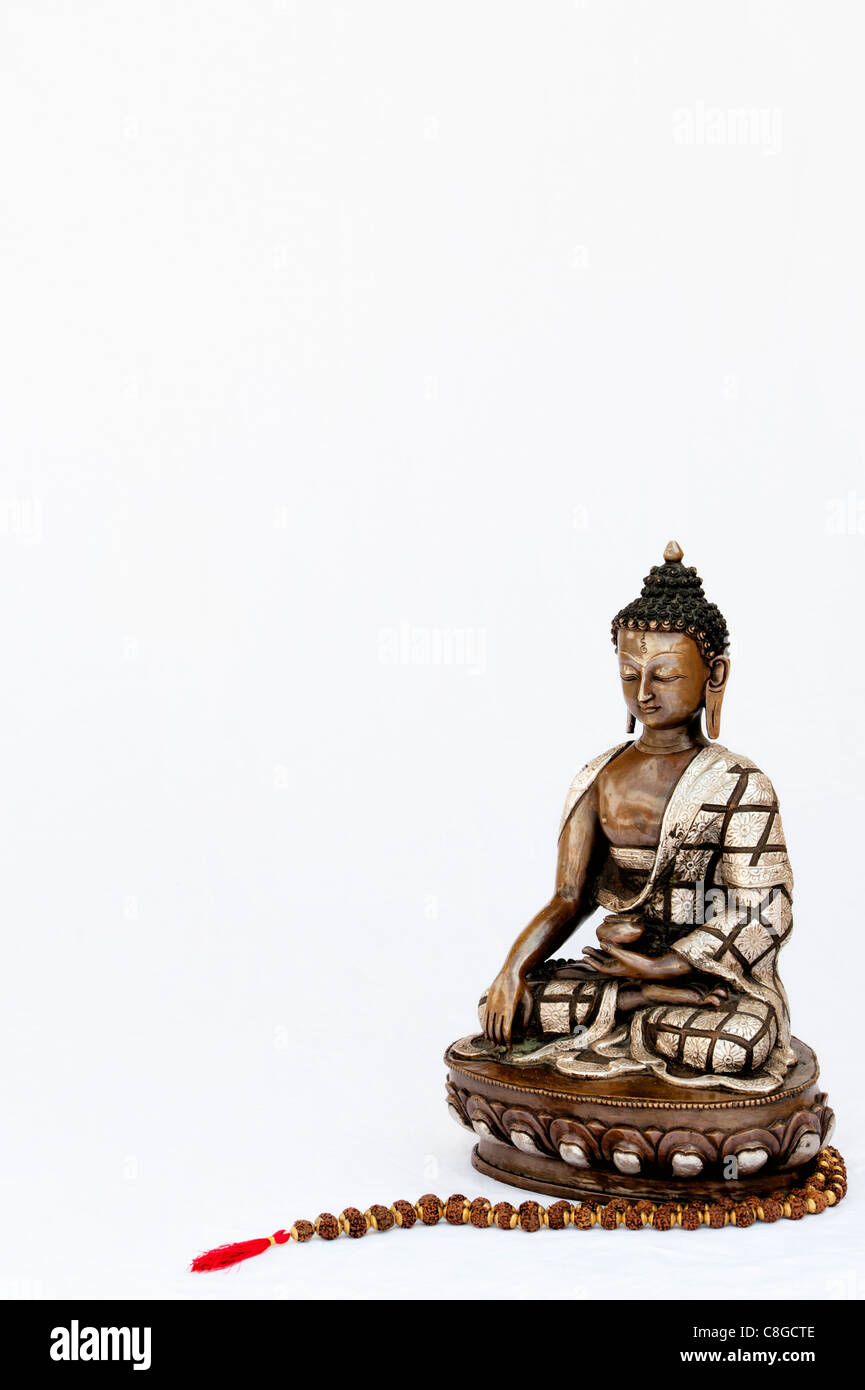 Buddha-Statue mit indischen Rudraksha / Japa Mala Gebetskette auf weißer Hintergrund Stockfoto