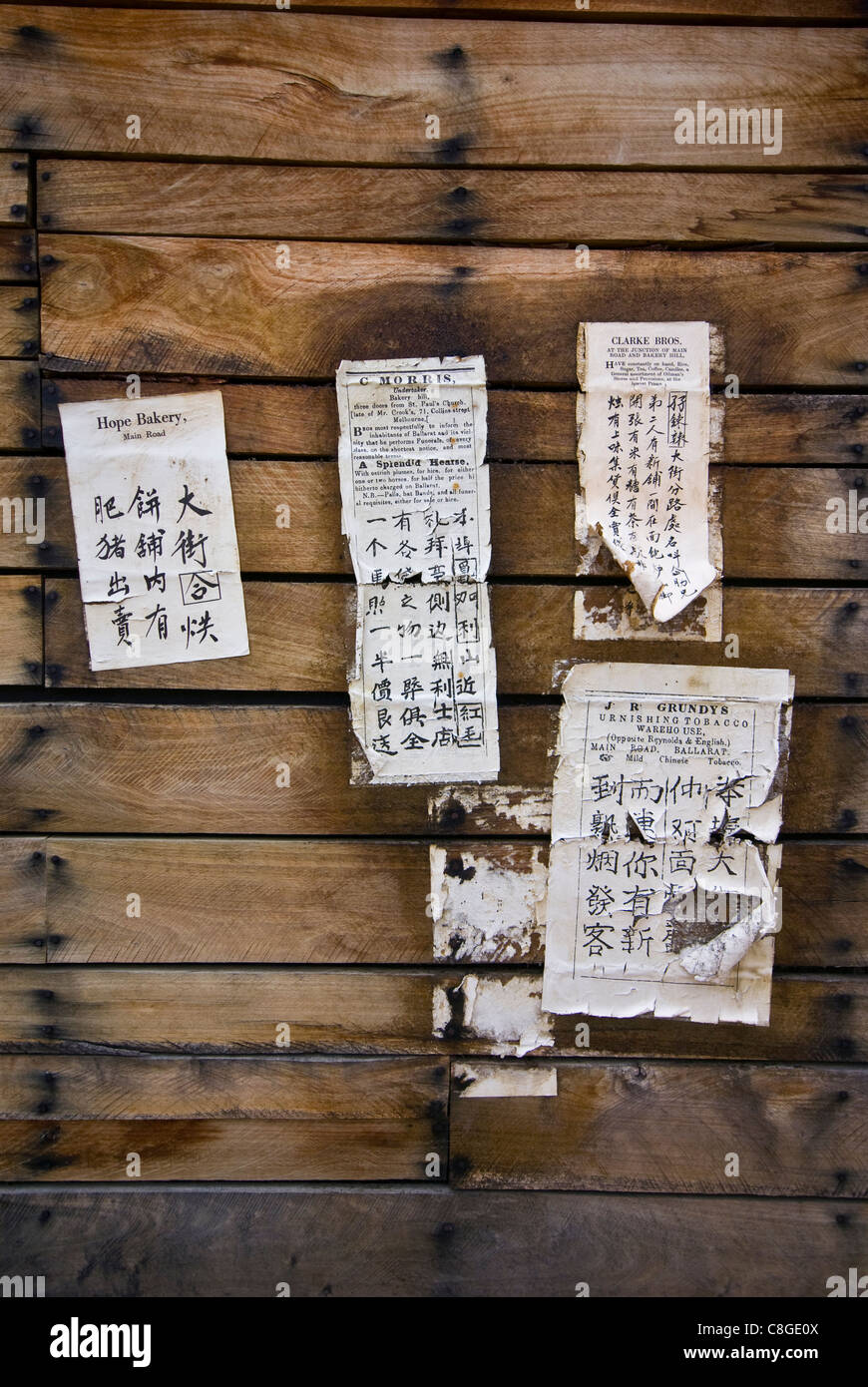 Chinesische Schrift auf gedruckte Bekanntmachungen an eine Scheune Wand geschrieben. Stockfoto