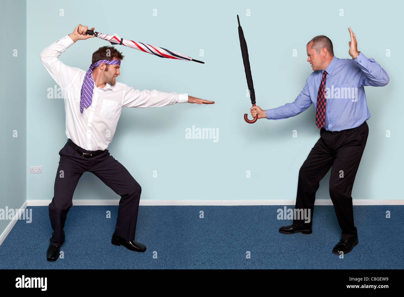 Foto von zwei Geschäftsleute mit einem Schwertkampf mit Sonnenschirmen, gutes Bild, Konflikt, Rivalität oder Meinungsverschiedenheiten zu vermitteln. Stockfoto