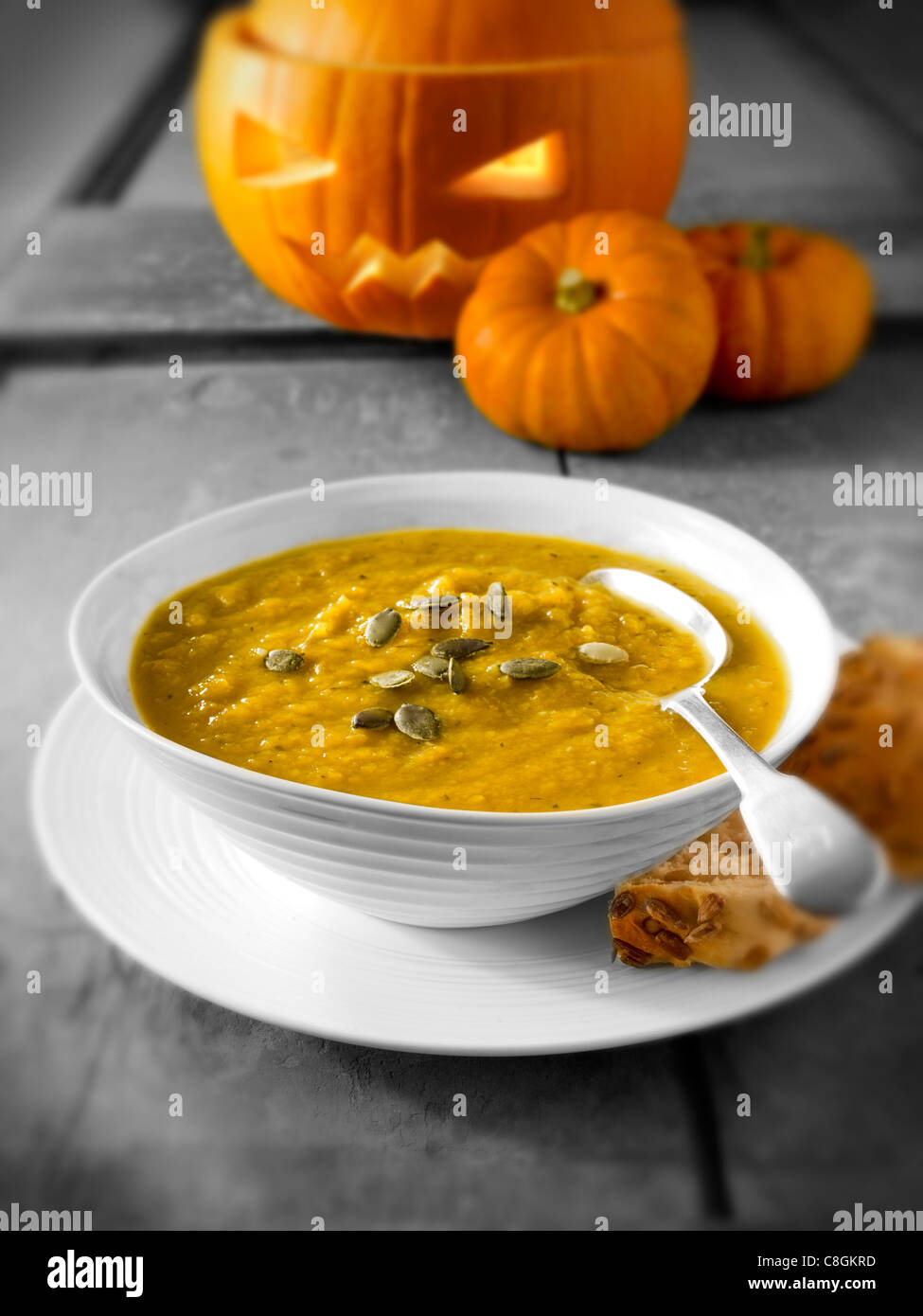 & Speck Kürbis-Suppe mit einem traditionellen Haloween-Kürbis mit einem geschnitzten Gesicht Stockfoto