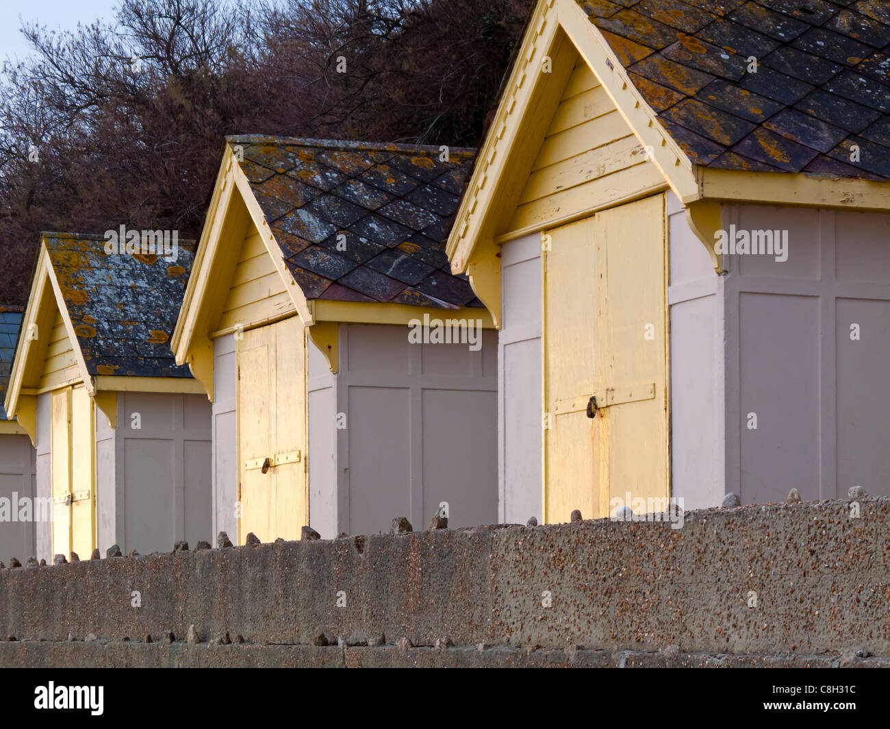Drei traditionelle hölzerne Strandhütten an der Strandpromenade in Folkestone in Kent England UK Stockfoto