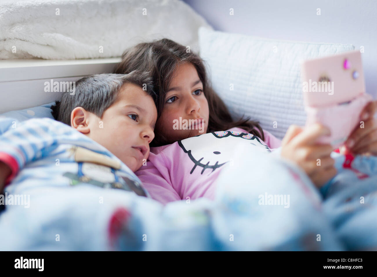 Kinder, die ein Computer-Spiel im Bett Stockfoto