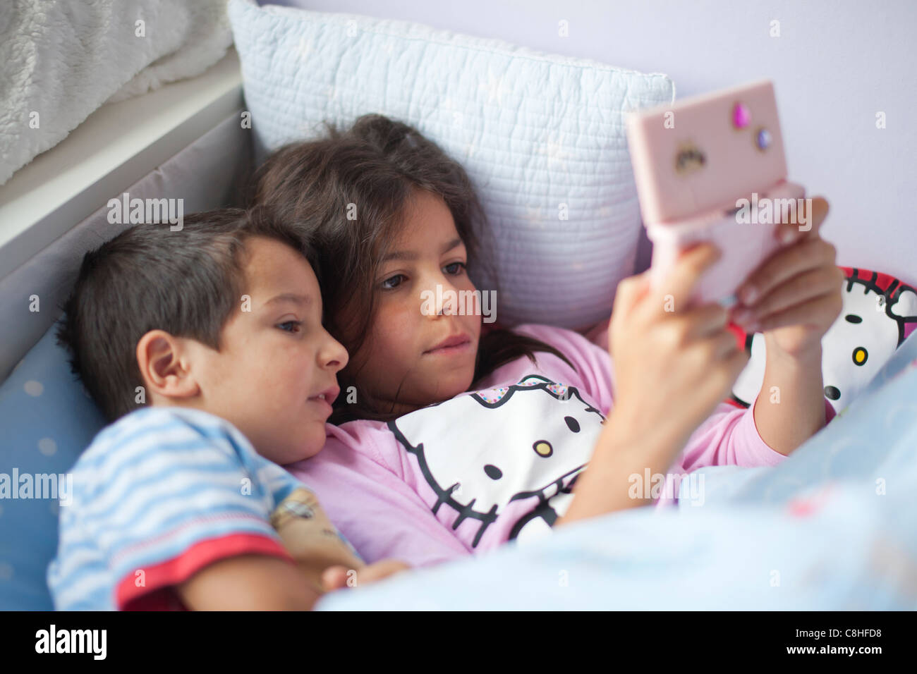Kinder, die ein Computer-Spiel im Bett Stockfoto
