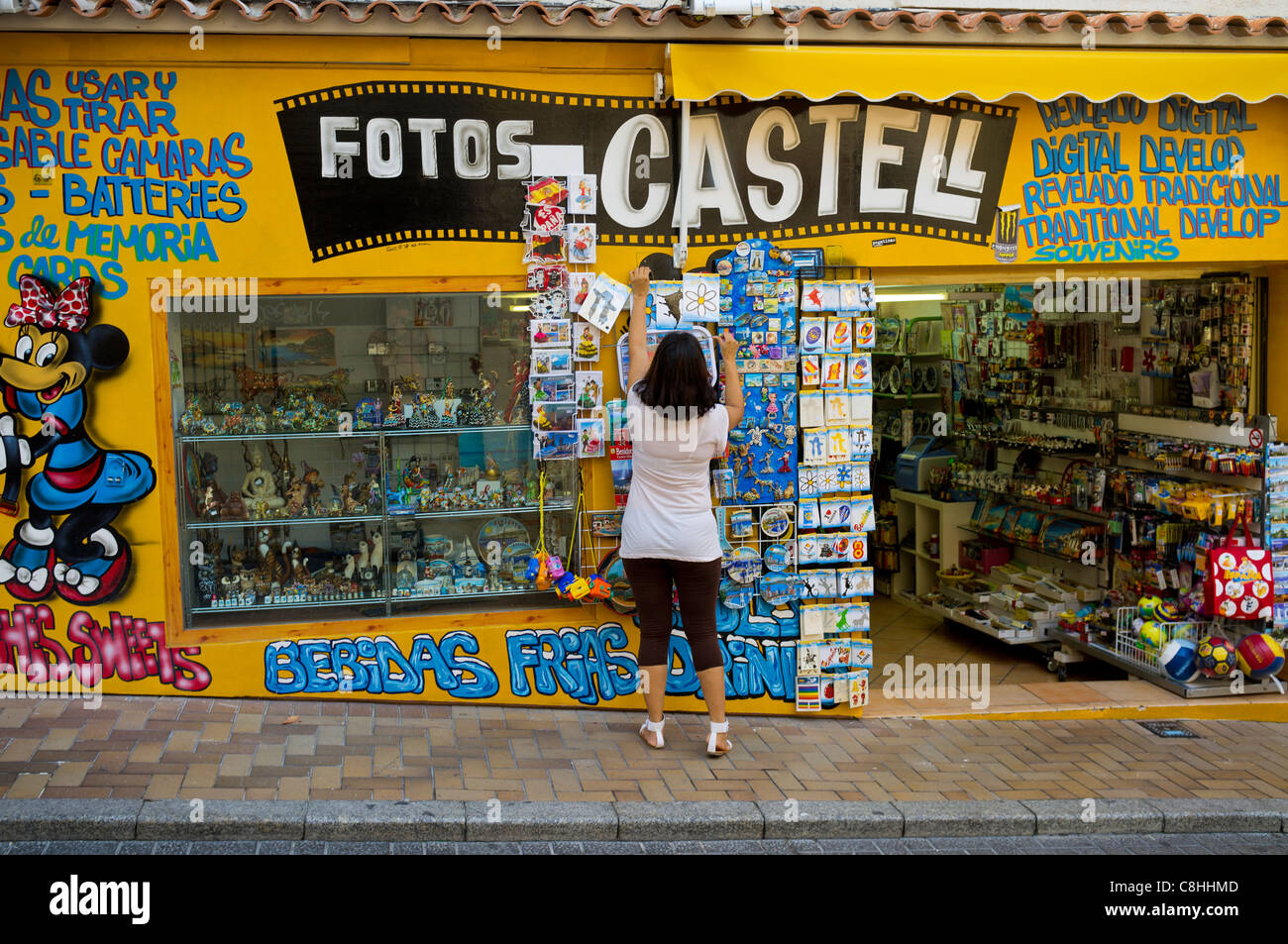 Ein Ladenbesitzer aufräumt, ihre Anzeige in einem Touristen-Shop in der Altstadt von Benidorm. Stockfoto