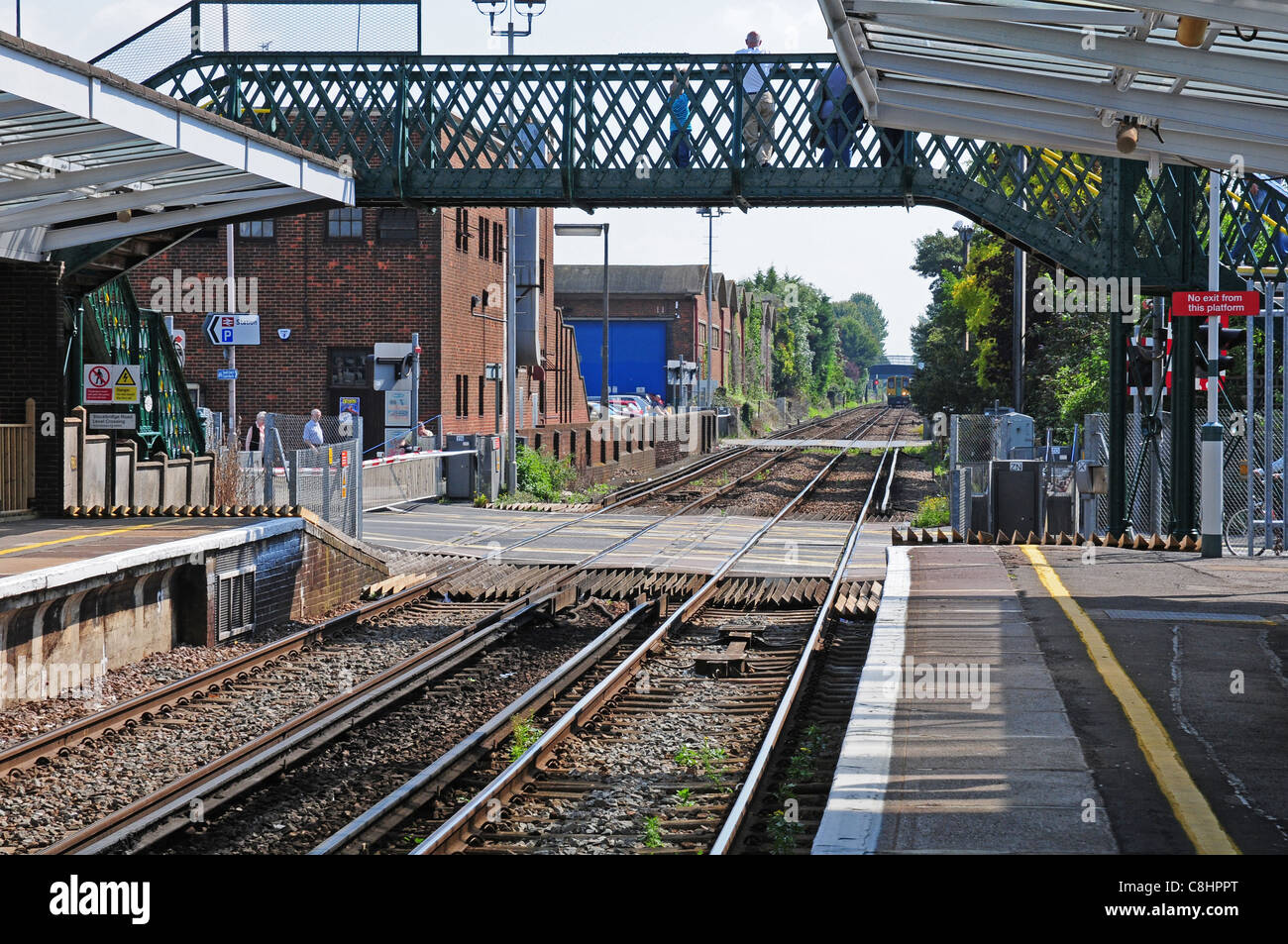 Blick vom Bahnhof Chichester zeigt zwei Bahnübergänge und nähert sich dem Zug. Stockfoto
