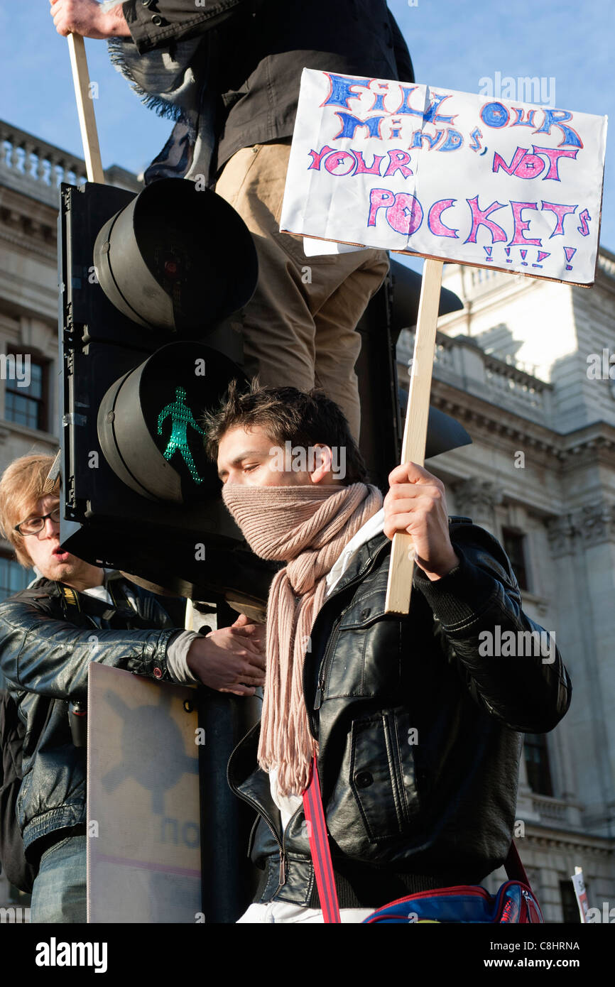 Studentischen Demonstranten Klettern auf Ampeln mit Plakaten während Gebühren Studentenproteste im Parlament Square London 12.09.2010 Stockfoto