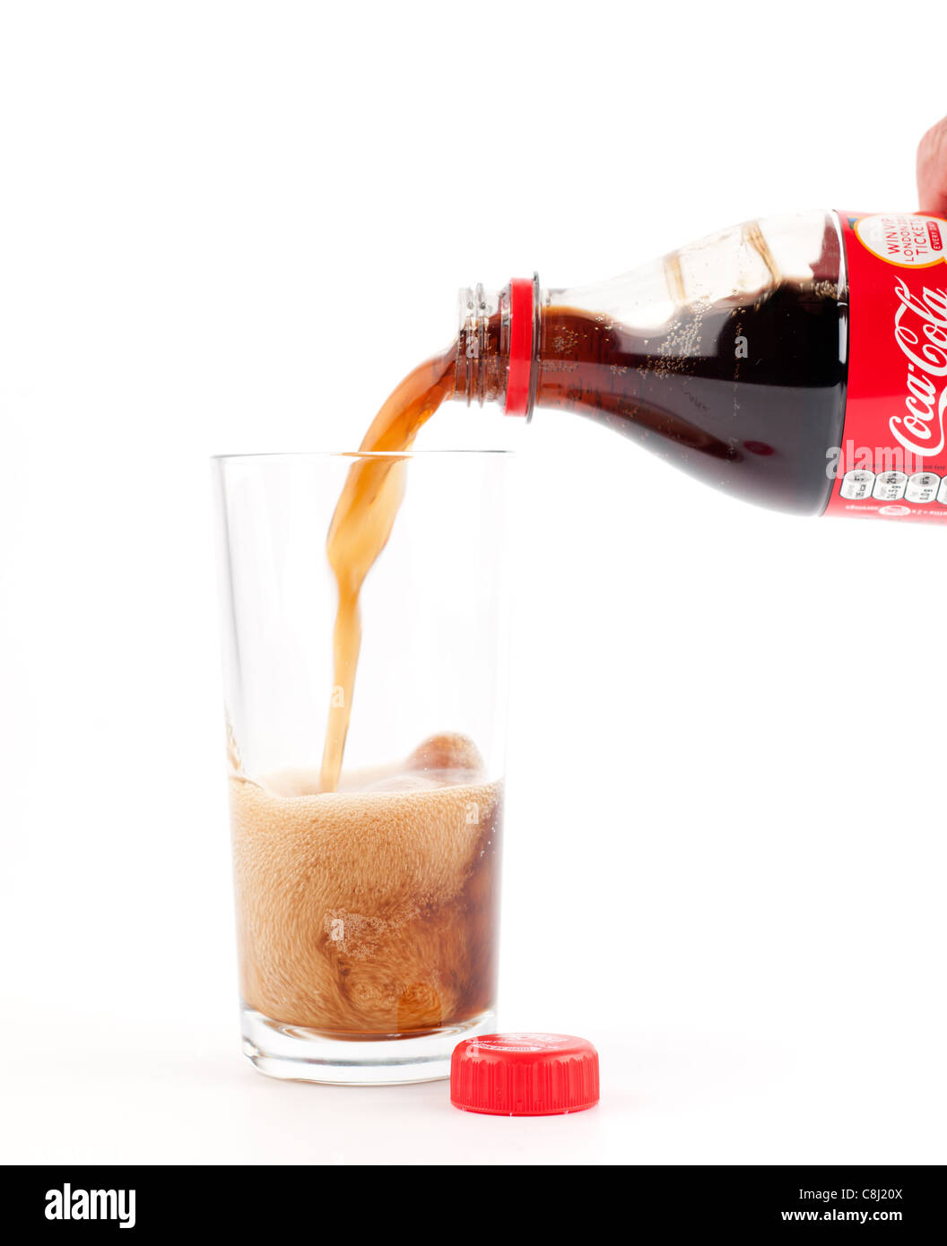 Flasche Coca Cola wird in einem klaren einfachen Glas gegossen Stockfoto