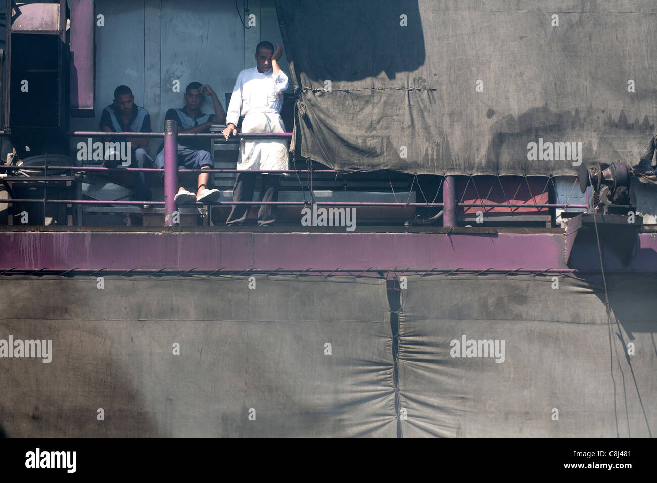 Nahaufnahme der drei Besatzungsmitglieder des Nil-Kreuzfahrt-Schiff sitzen in der rauchigen Dämpfe in das Heck des Schiffes, eine Rauchen einer Zigarette Stockfoto