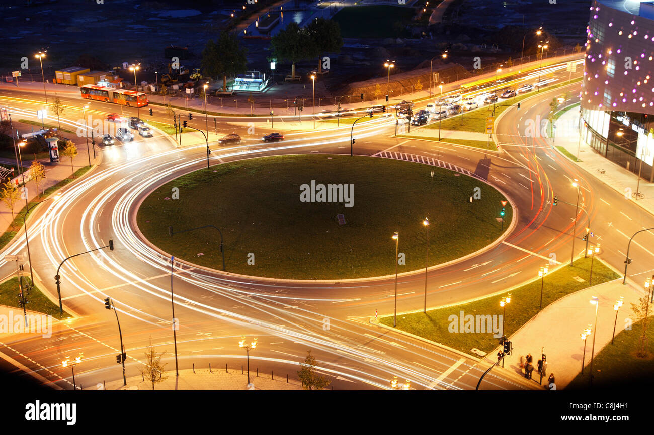 Kreisverkehr in der Stadt. In der Nacht, die Lichter der Autos im Kreis herum. Durch Ampeln gesteuert. Stockfoto
