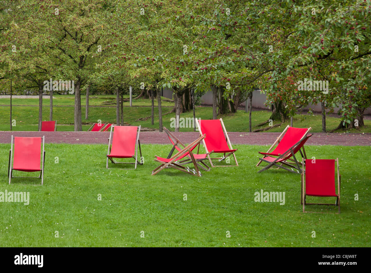 Rote leere Liegestühle im Garten des jüdischen Museums. Berlin, Deutschland. Stockfoto