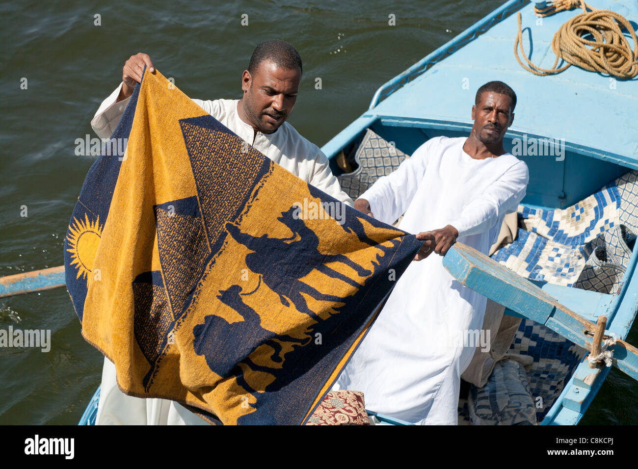 Ein Markt-Händler hält ein Handtuch als eine weitere Zeilen das Boot sind sie an Esna Schleuse Ägypten Stockfoto