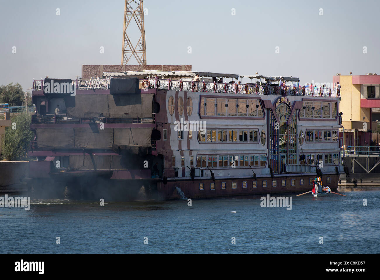 Eine Nil-Kreuzfahrt Schiff Schlange, um Esna Schleuse Ägypten zeigt das Rauchen verschmutzt Heck als Händler Zeile bis es passieren Stockfoto