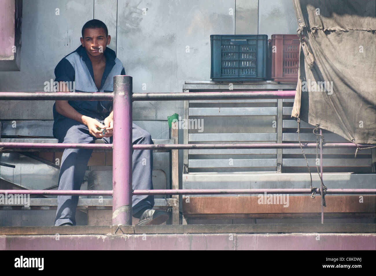 Ein Besatzungsmitglied des Nil Kreuzfahrt Boot sitzen in der rauchigen Dämpfe in das Heck des Schiffes Stockfoto