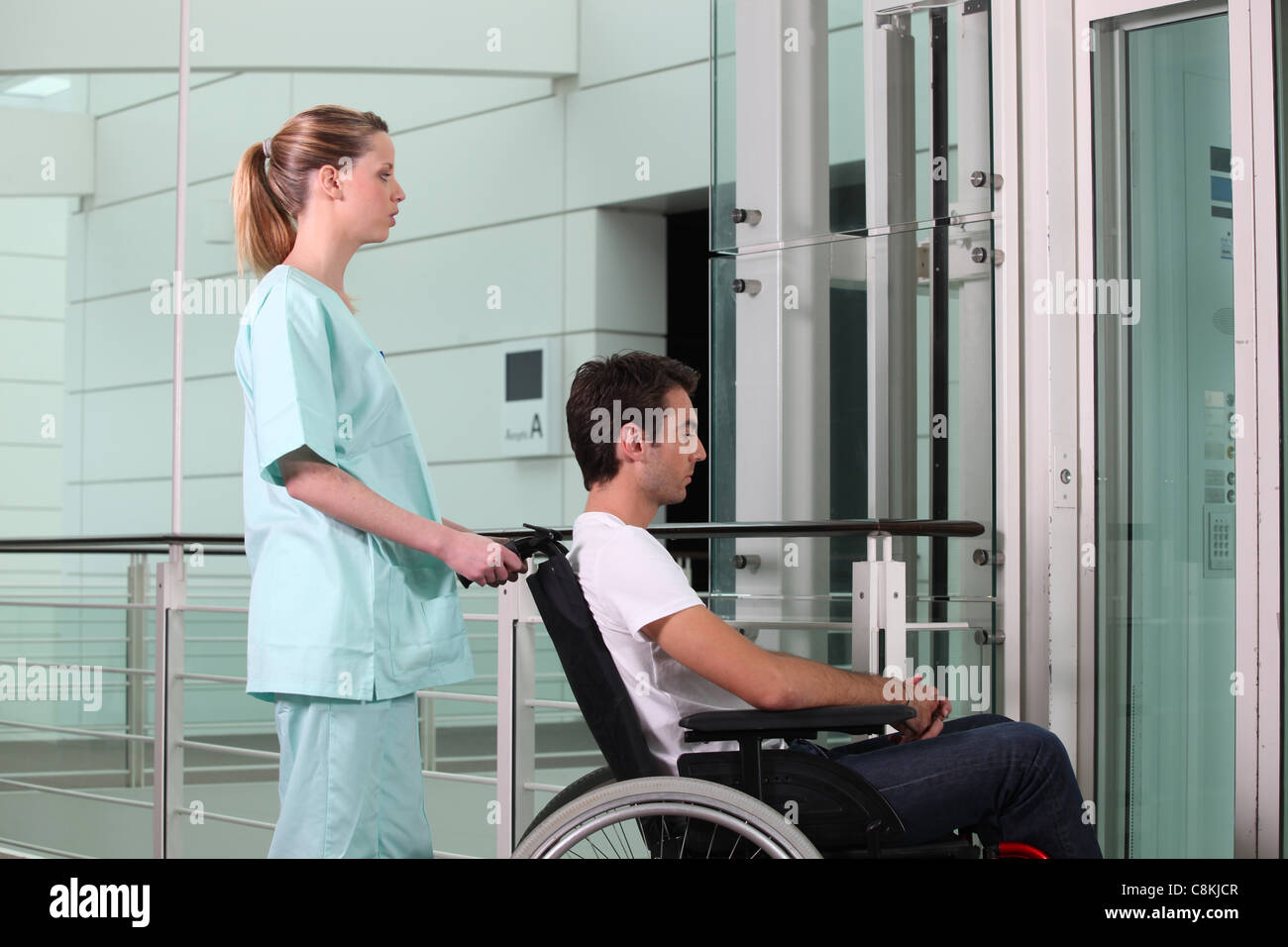 Krankenschwester helfen Mann im Rollstuhl Stockfoto