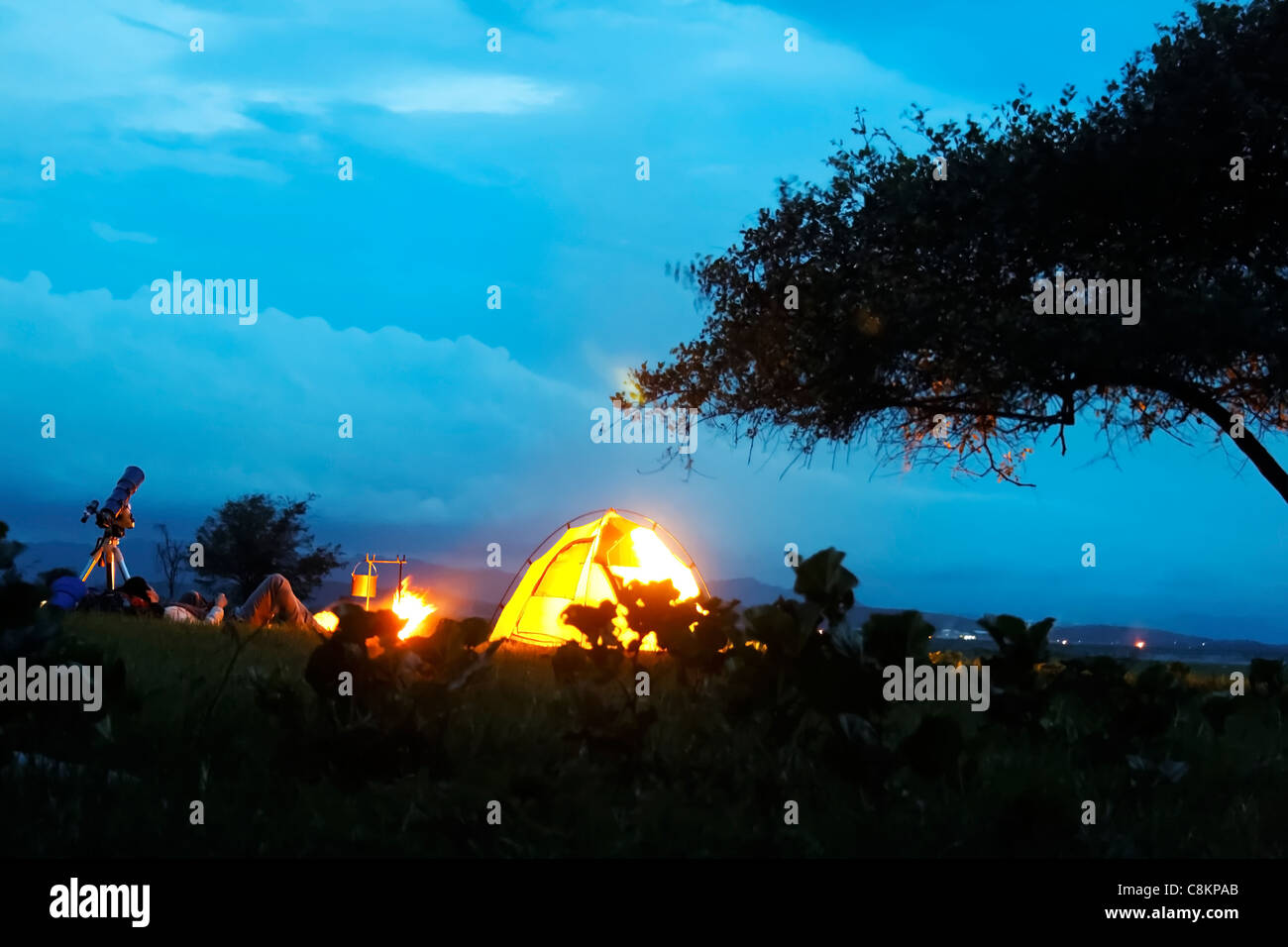 horizontale Porträt Landschaft Silouhette entfernten Campingplatz Camp fire Mondnacht Moonlight Himmel Wolken Baum Ernte Margen Überhang Stockfoto