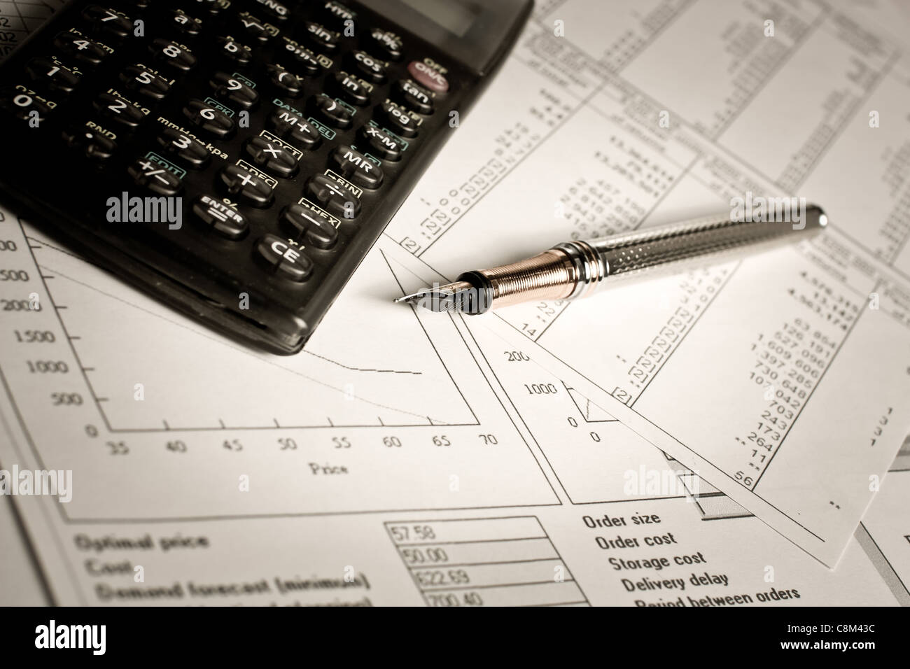 Finanz-Charts und Tabellen mit Taschenrechner und Stift auf dem Tisch liegen Stockfoto