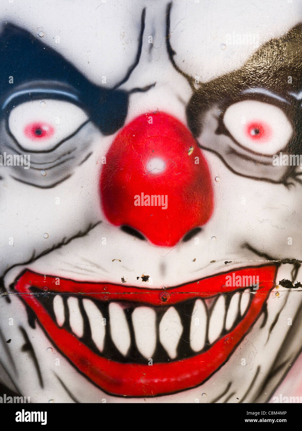 Eine böse Clowns-Gesicht gemalt am Gehäuse für eine Geisterbahn. Stockfoto