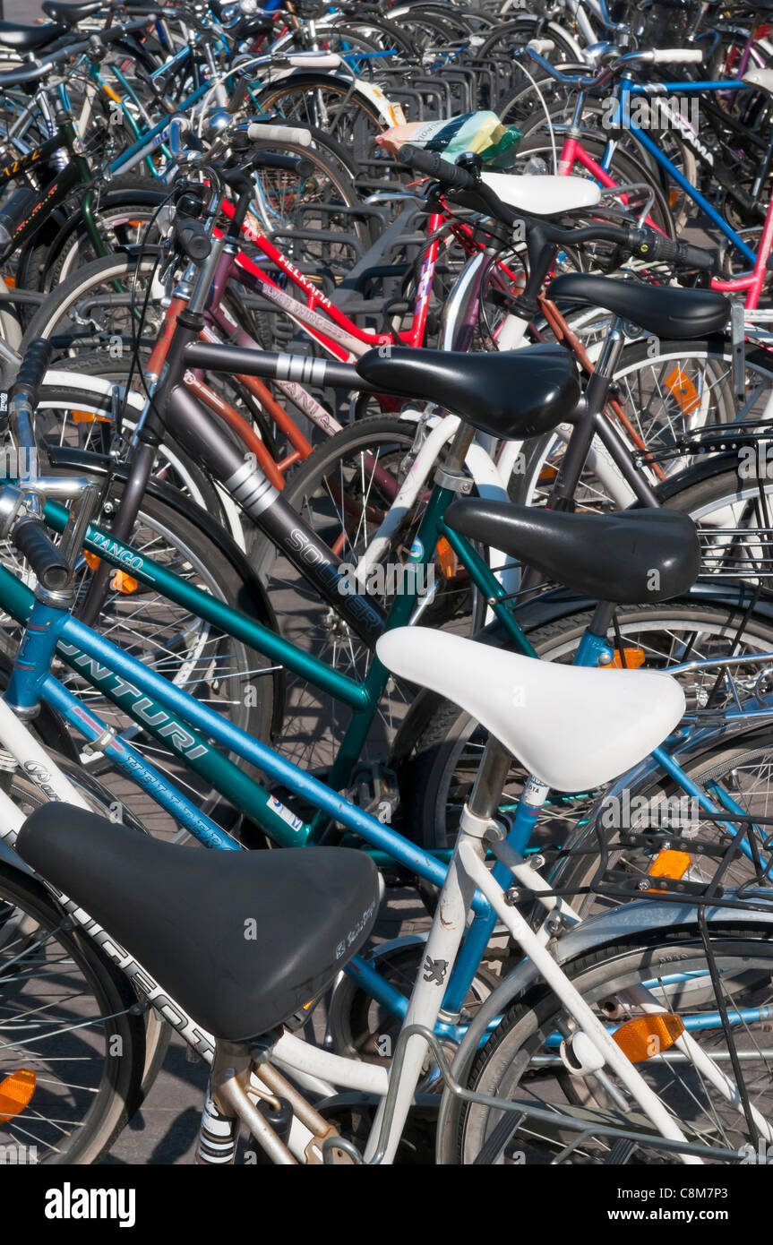 Eine große Gruppe von Fahrrädern angekettet an Regale vor dem Bahnhof in Helsinki, Finnland. Stockfoto