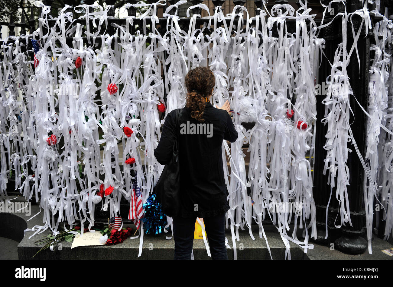 Eine Frau knüpft ein Band auf dem Geländer vor St. Pauls Kapelle in lower Manhattan zum zehnten Jahrestag der 9/11 Angriffe. Stockfoto