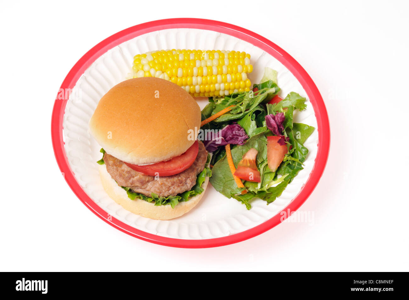 Türkei Burger mit Salat und Tomaten in Brötchen in rot Retro Kunststoffkorb mit Maiskolben und Salat auf weißem Hintergrund Ausschnitt. Stockfoto