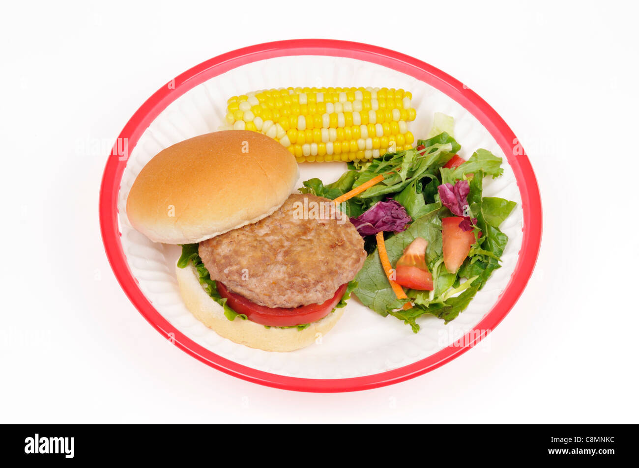 Türkei Burger mit Salat und Tomaten in Brötchen mit Ohr von Mais und Salat in rot Retro Kunststoffkorb auf weißem Hintergrund Ausschnitt. Stockfoto