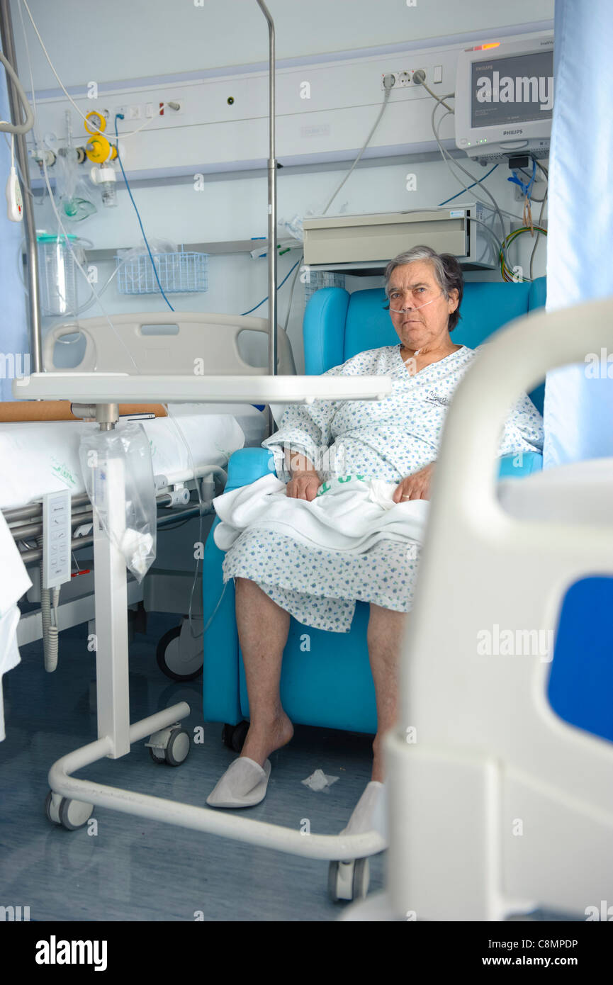 Ältere Frau saß neben ihrem Bett in einer Krankenstation Stockfoto