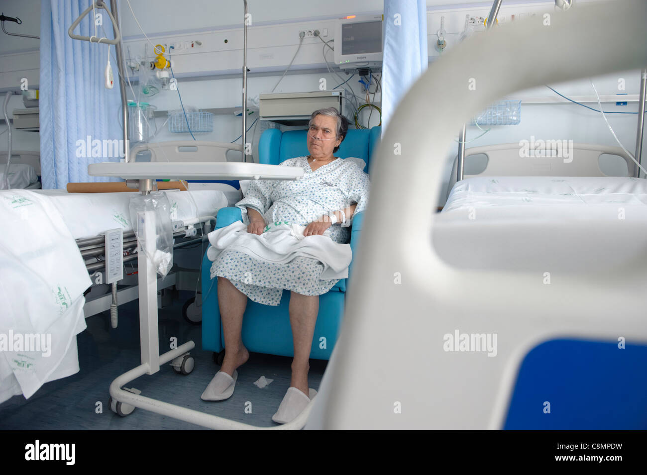 Ältere Frau saß neben ihrem Bett in einer Krankenstation Stockfoto