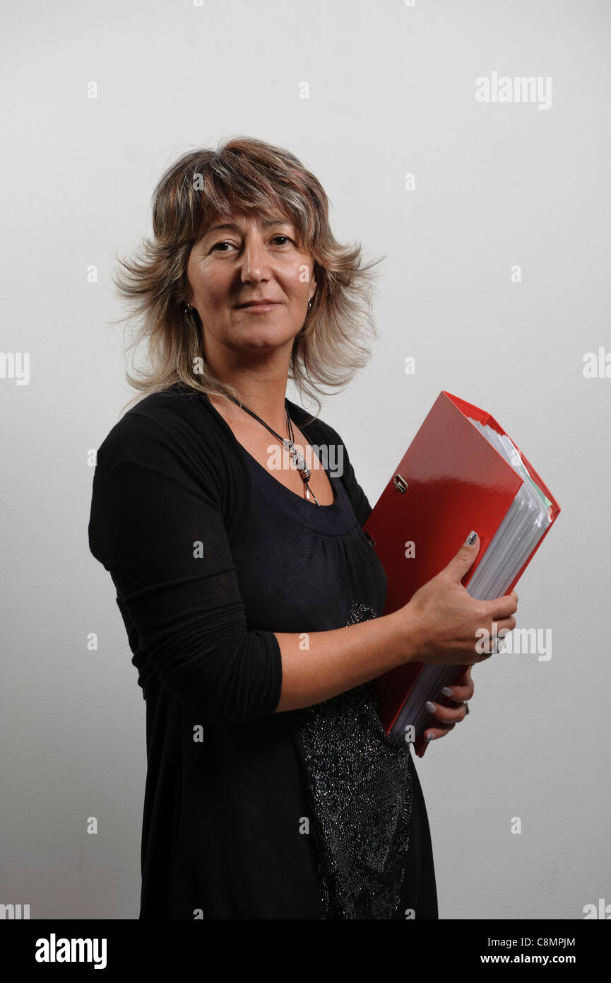 Weibliche Büroangestellte hält Dateiordner auf Ringbücher Stockfoto