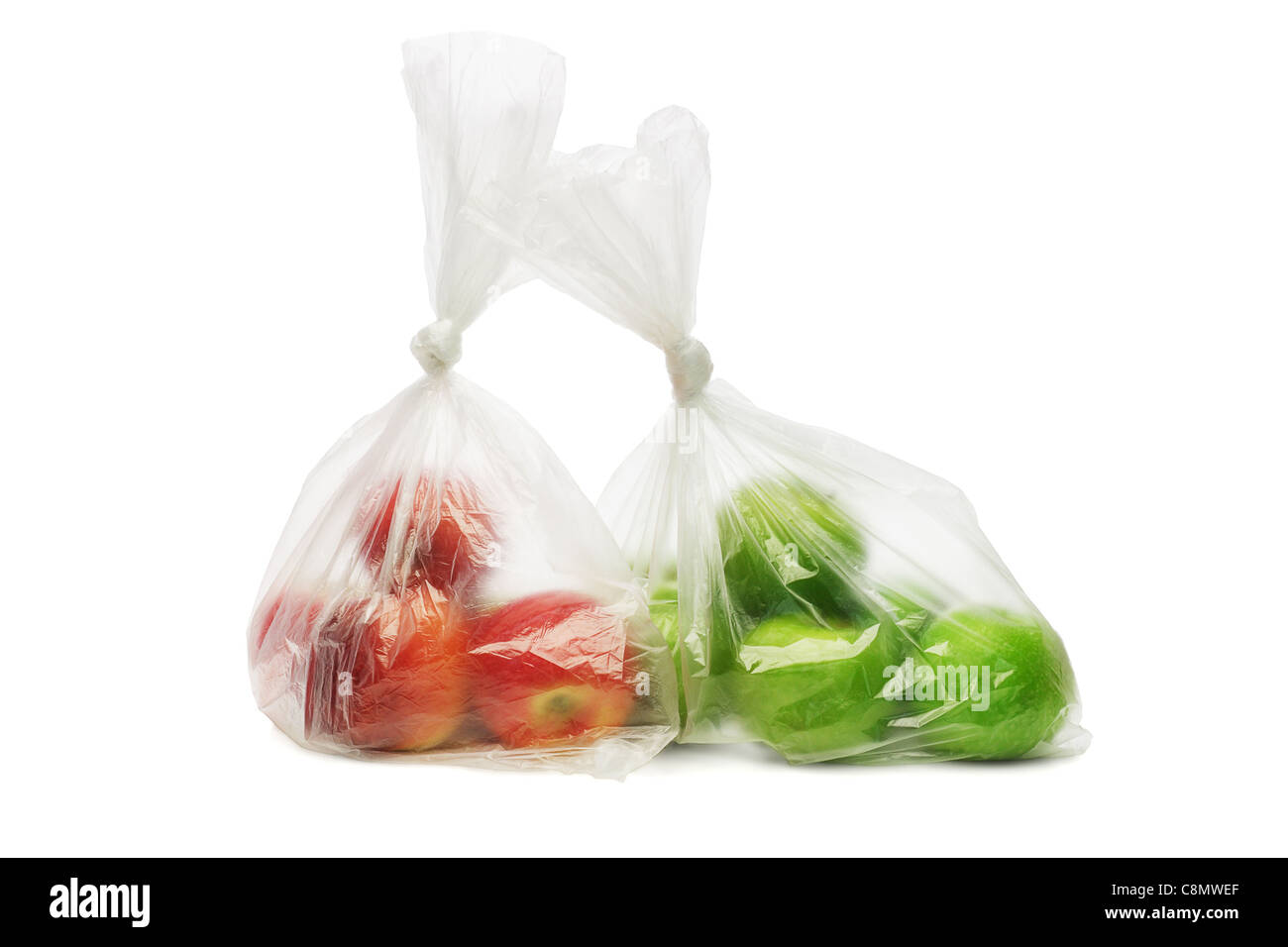 Zwei Plastiktüten von roten und grünen Äpfeln auf weißem Hintergrund Stockfoto