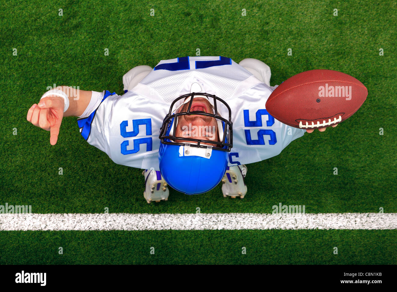 Obenliegende Foto eines American Football-Spielers machen ein Touchdown-fest nach oben in der Luft mit seinem Finger angehoben. Stockfoto