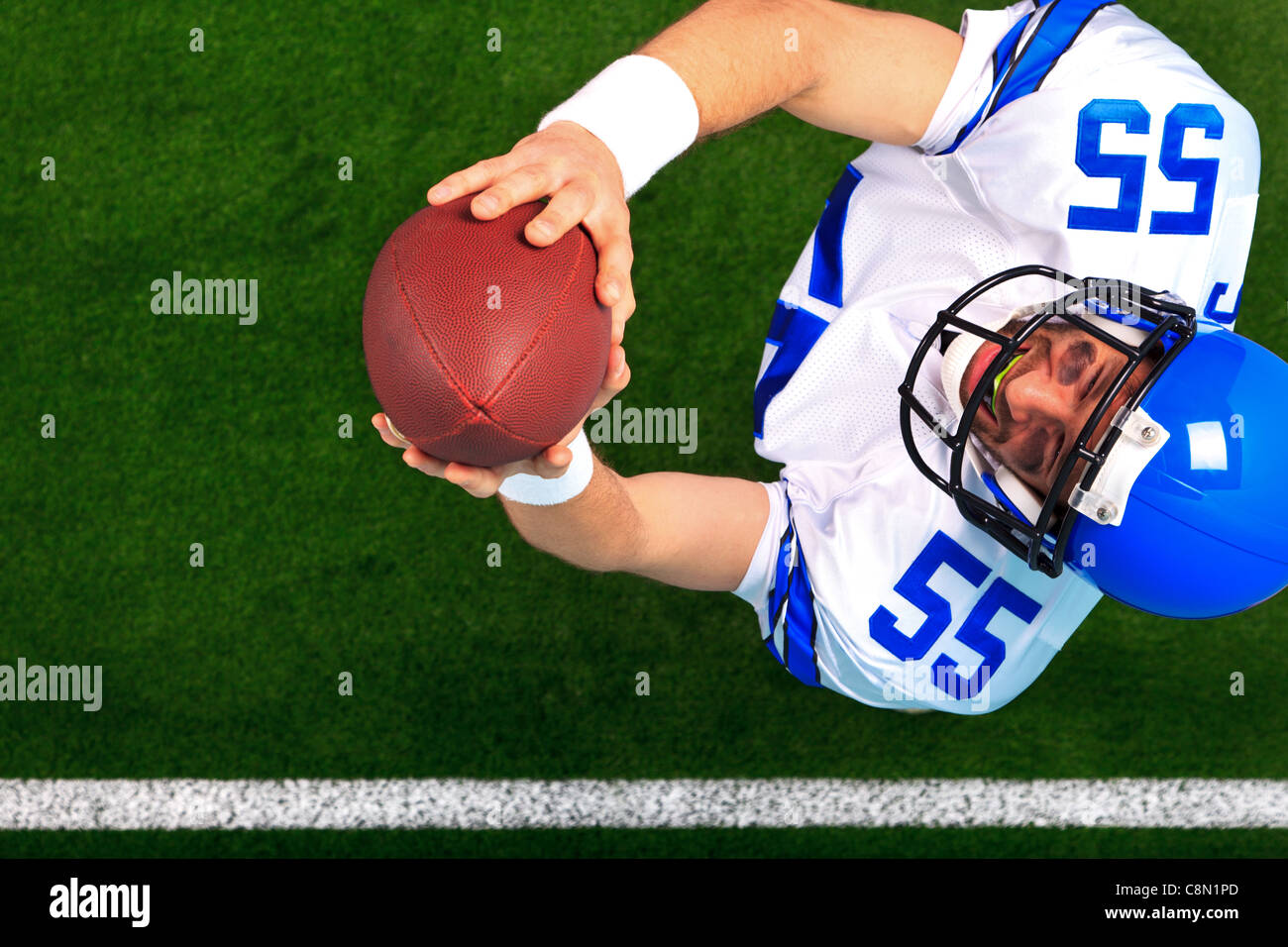 Obenliegende Foto ein American Football Spieler Wide Receiver den Ball in der Luft zu fangen. Stockfoto